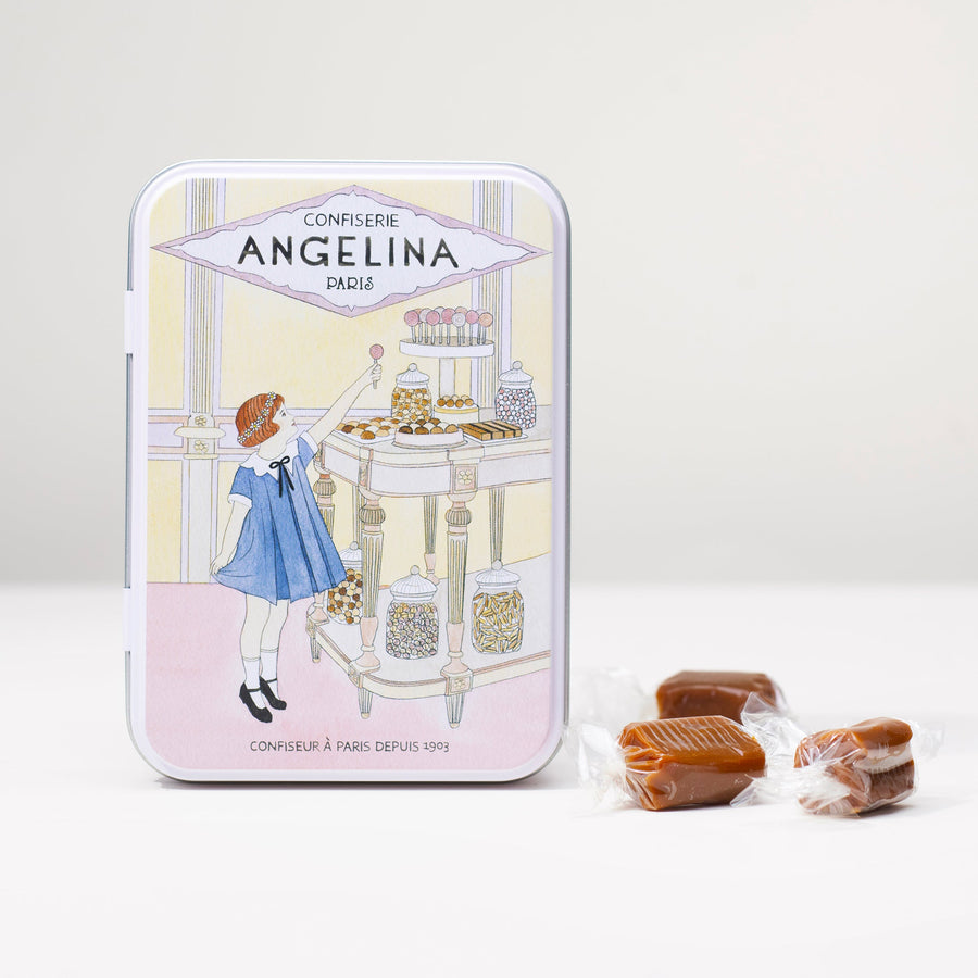 Front view of the Angelina salted butter caramel tin with an illustrated girl choosing sweets in a Parisian confectionery.
