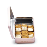 An open Angelina tin filled with individually wrapped gold Mini Gianduja chocolates.